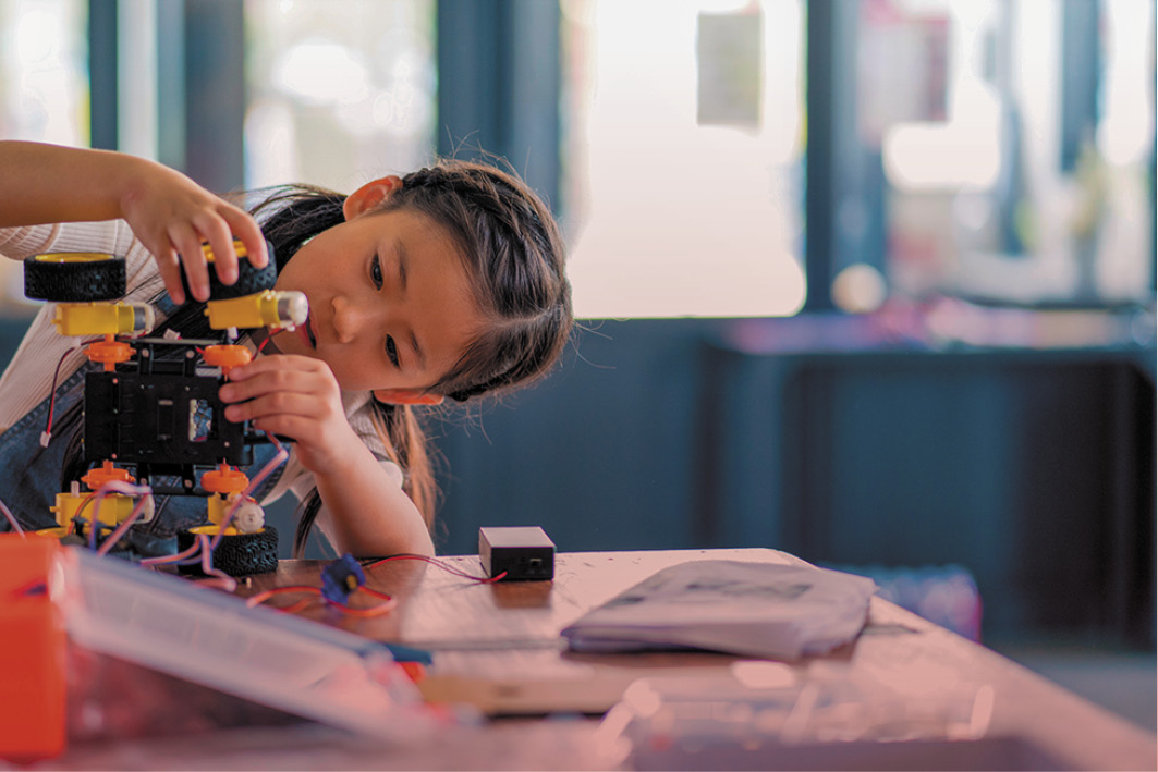 A young student building a model in a classroom