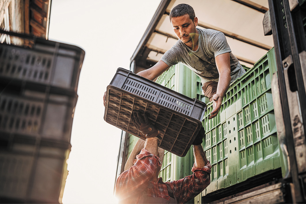 Men unloading crates from a lorry