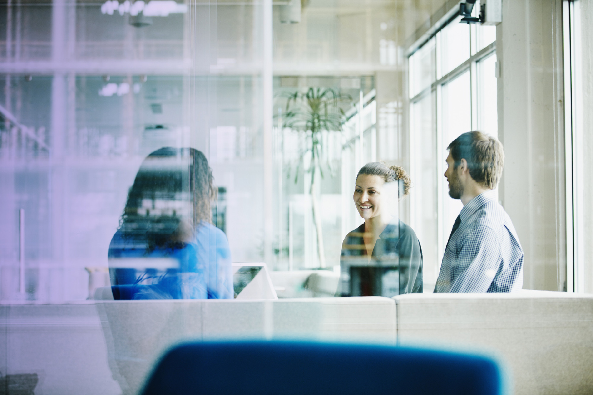 Smiling businesswoman leading team meeting with colleagues in office conference room