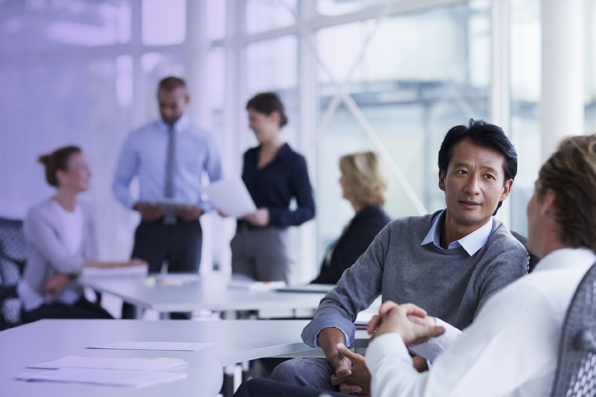 Businessman discussing with male colleague in office